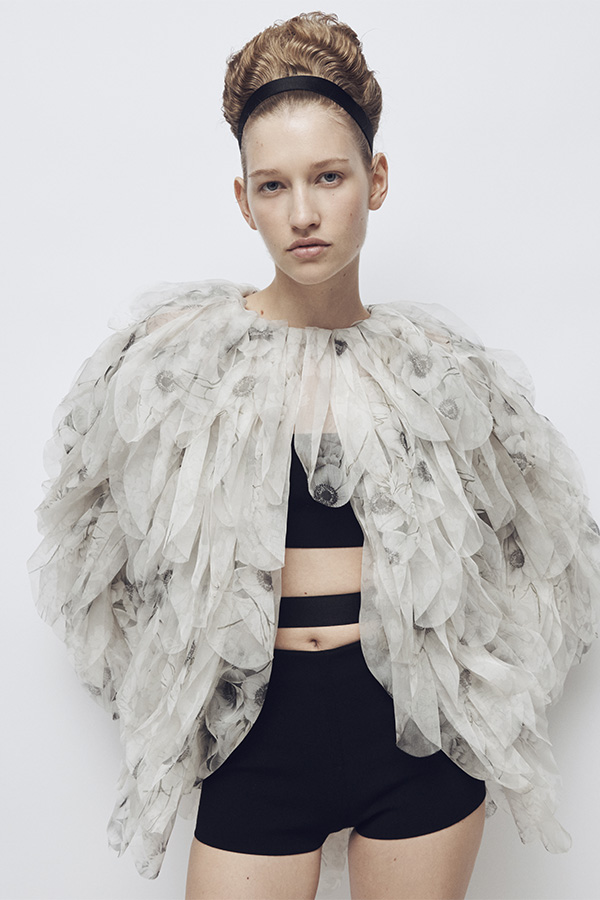 Показ коллекции Max Mara Весна-лето 2026 — модель в куртке белого цвета с деталями, топе-бандо и шортах черного цвета.