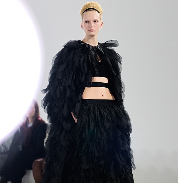 Показ коллекции Max Mara Весна-лето 2026 — модель на подиуме в образе в черном цвете: пиджак и юбка с деталями.